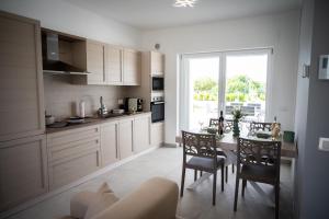 a kitchen with a table and chairs and a window at Likehome Ponente Levante 2 Ville luxury Pool 12pxs in Taranto