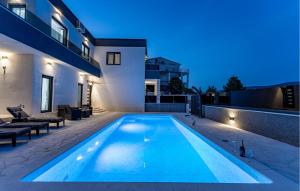 a swimming pool in the backyard of a house at night at Lovely Home In Pridraga in Pridraga