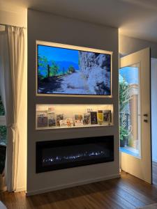 a living room with a flat screen tv on a wall at Casa Pitem in Nago-Torbole