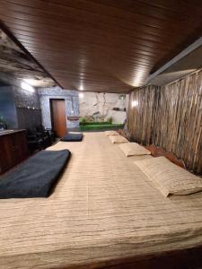 a large bed in a room with many pillows on it at Escape Natural Farm Stay - Cave in Kanthalloor