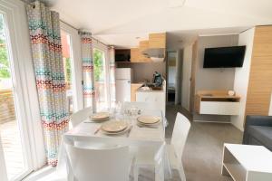 a dining room and kitchen with a white table and chairs at Loray des Bois - Cabane - Tipi - Cottage in Loray
