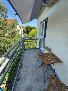 a balcony with a bench and an umbrella at Gästeapartment Schkeuditz in Schkeuditz