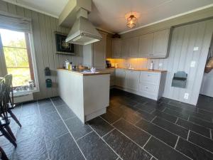 a large kitchen with white cabinets and a sink at Nice And Central With Terrace in Beitostøl