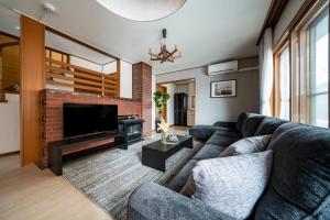 札幌市にあるE-US Naebo HOUSEのソファとテレビのあるリビングルーム