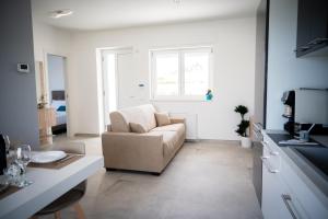 a living room with a couch and a table at Likehome Ponente Levante 2 Ville luxury Pool 12pxs in Taranto