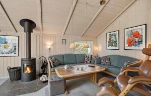 a living room with a couch and a fireplace at Awesome Home In Rudkøbing With Sauna in Spodsbjerg