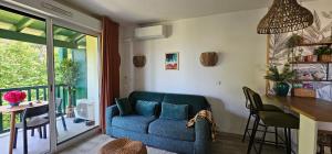 ein Wohnzimmer mit einem blauen Sofa und einem Tisch in der Unterkunft Pause Luzienne à deux pas de la plage in Saint-Jean-de-Luz