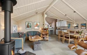 a living room with a fireplace and a dining room at Awesome Home In Rudkøbing With Sauna in Spodsbjerg