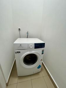 a washing machine in a corner of a room at KL Central 32 Floor KLCC View in Kuala Lumpur