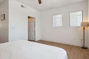 グレンデールにあるCozySuites Glendale - Westgate w pool 14の白いベッドルーム(ベッド1台、窓2つ付)