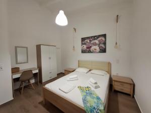 a small bedroom with a bed and a desk at Mamanis Studios in Loutra Edipsou