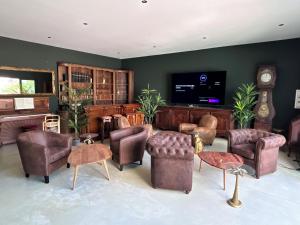 a living room filled with furniture and a flat screen tv at La Maison Coloniale Suites privatives de prestige in Torreilles