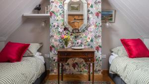 a room with two beds and a table with a mirror at Little Coach House in Beckley