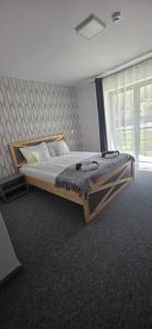 a large bed in a room with a large window at Panorama Budești in Budeşti