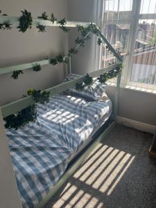 a bed with plants on it in a room at Beautiful three bedroom house in Liverpool