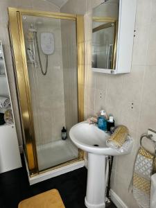 a bathroom with a white sink and a shower at Beautiful three bedroom house in Liverpool +17 photos