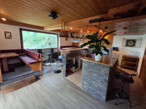 a room with a bar and a kitchen with a counter at Pension Razil XO in Ladis