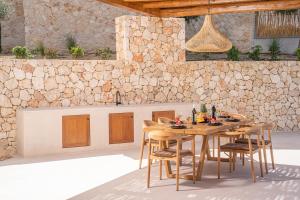 a wooden table and chairs in a patio at Lithos Art Villas - Euphoria in Lakithra
