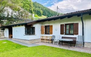 a white house with a table and chairs in a yard at LITTLE HIDEAWAY zillertal in Hart im Zillertal