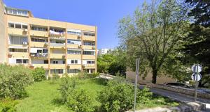 ein Mehrfamilienhaus mit einem Rasen davor in der Unterkunft Apartment Bella in Split
