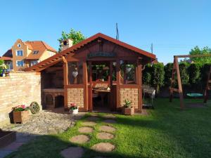 a gazebo with a table in a yard at Chata Jana in Łeba