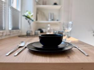 Una taza negra y un plato sobre una mesa de madera en A nette Wohnung, en Füssen 18 fotos más