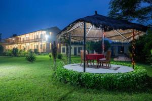 巴拉特布尔Badreni Jungle Resort, Sauraha的院子里凉亭下的桌椅