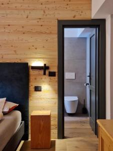 a bedroom with a bed and a bathroom with a tub at Laras Chalet in Bocenago +15 photos