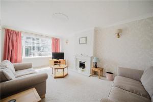 a living room with a couch and a fireplace at Large 4 bedroom home in Boston Spa village In-between York, Harrogate and Leeds, Sleeps 9 in Boston Spa