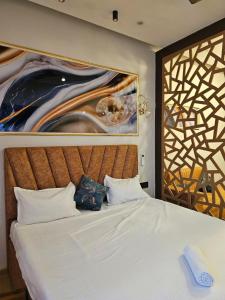 加济阿巴德Square Residency的卧室里有一张床,墙上挂着一幅大画