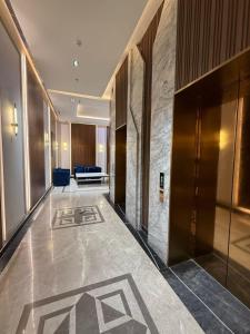 a hallway of a hotel lobby with a blue couch at Square Residency in Ghaziabad