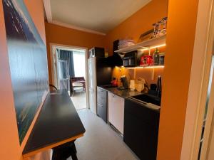 a kitchen with orange walls and a black counter top at Bakkebo in Åndalsnes
