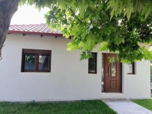 a white house with a brown door at Anastasia in Leptokarya