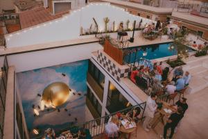 Draufsicht auf eine Hotellobby mit Pool und an Tischen sitzenden Personen. in der Unterkunft Hotel Divino by Fimedhotels in Figueres