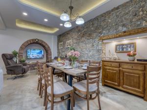 a dining room with a table and chairs and a stone wall at Casa Conrad in Opatija