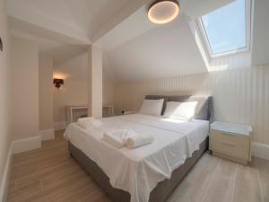 a bedroom with a bed with white sheets and a window at CASA AL MARE RESIDENCE in Bečići