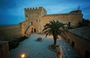 a building with a palm tree in front of it at Valparadiso Apartment in Naro
