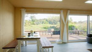 a living room with a table and a sliding glass door at The Chaeum in Seogwipo