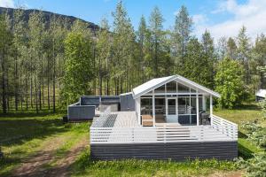 a house with a white deck in a field at Cozy Cabin - Golden Circle in Laugarvatn