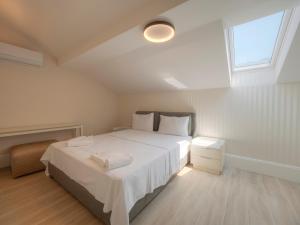a bedroom with a large white bed and a window at CASA AL MARE RESIDENCE in Bečići