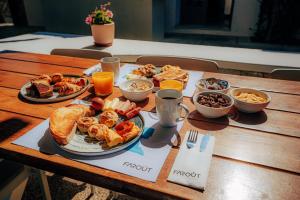 a wooden table with plates of food on it at FarOut - BeachResort & Camping in Mylopotas