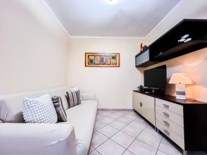 a living room with a white couch and a flat screen tv at Ginestra house in Olbia