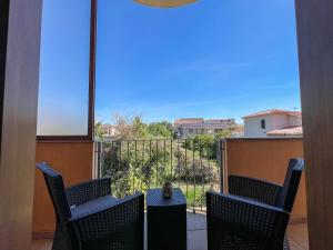 a balcony with chairs and a table with a view at Ginestra house in Olbia