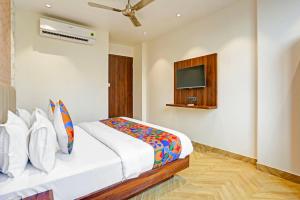a bedroom with a bed and a tv on the wall at FabExpress Baba's Inn Kirti Nagar in New Delhi +21 photos