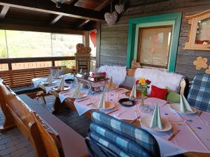 a room with tables and chairs on a porch at Apartment Haus Klingspitz Pilzegg in Embach