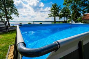 a large blue swimming pool with a hose at Mazurskie Apartamenty "Jak Tu Miło!" in Węgorzewo