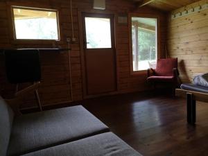 a room with a door and two windows and a couch at Ranč Nová Zem in Blatná Polianka