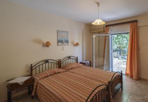 a bedroom with a bed and a sliding glass door at Vrokastro Apartments in Istro