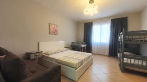 a bedroom with a bed and a couch and bunk beds at Helios Hotel&Hostel in Shkodër