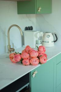 a bunch of pink flowers on a counter in a kitchen at Patri's glamp in Mariánské Lázně